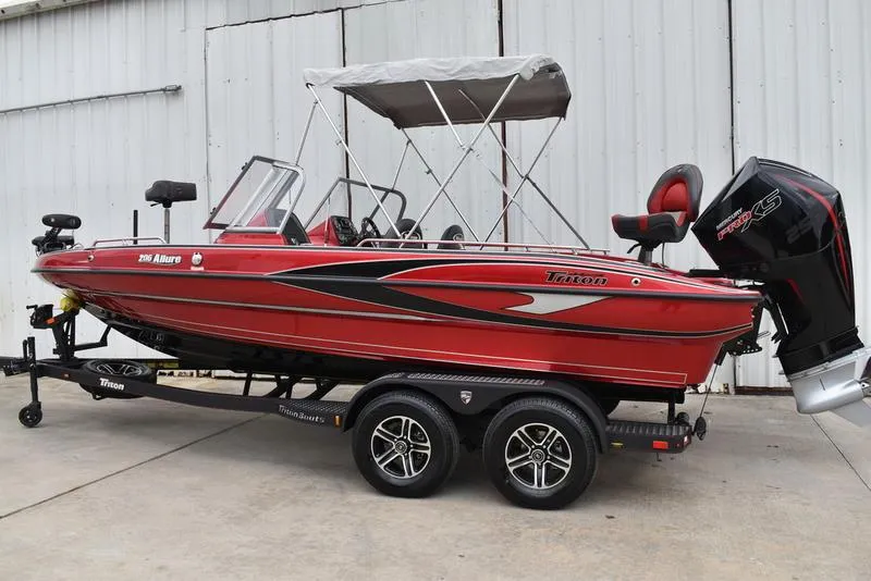Slide: The Image of 2024 Triton 206 Allure red fishing boat on trailer with canopy. - 5
