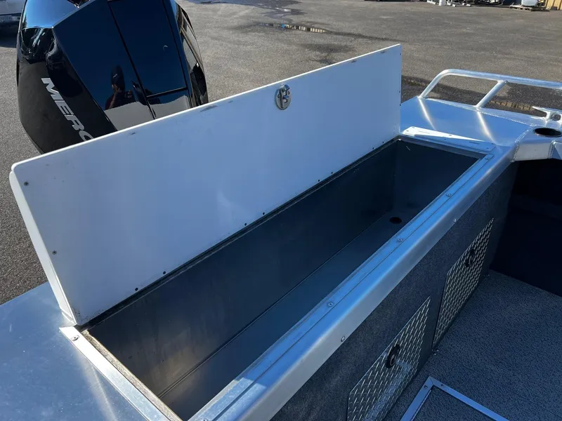 Slide: The Image of 2024 Thunder Jet 210 Luxor boat with open storage compartment and Mercury outboard motor. - 19