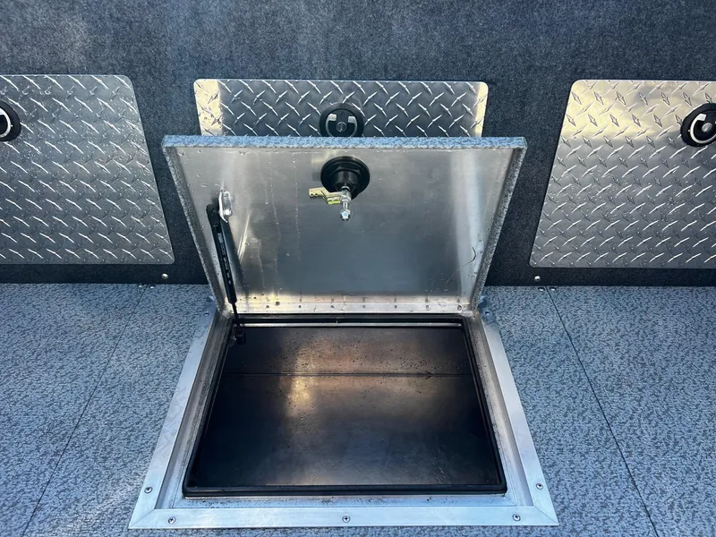 Slide: The Image of 2024 Thunder Jet 210 Luxor boat storage compartment with open hatch and diamond plate accents. - 20