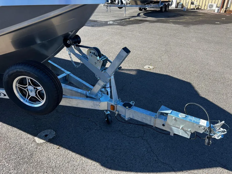 Slide: The Image of 2024 Thunder Jet 210 Luxor boat trailer hitch and wheel on asphalt. - 6