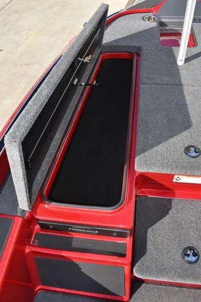 Slide: The Image of 2024 Triton 179 TrX boat with open storage compartment, red and gray interior. - 14