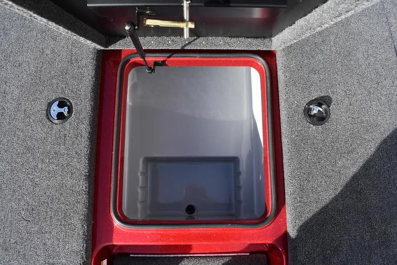 Slide: The Image of 2024 Triton 179 TrX boat storage compartment with red trim and gray interior. - 15