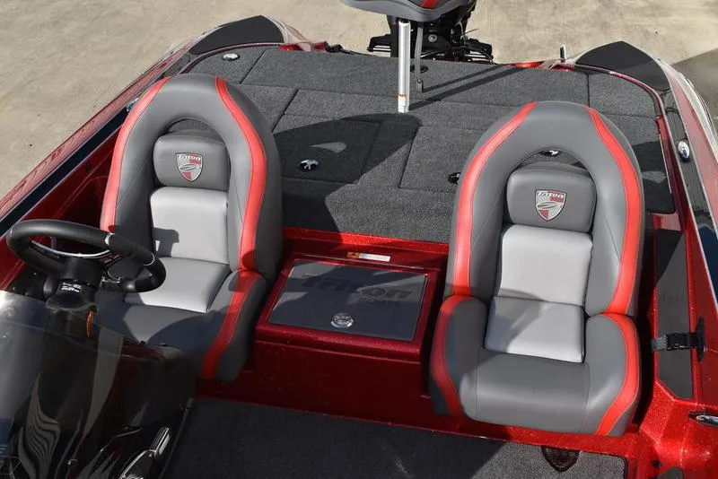 Slide: The Image of 2024 Triton 179 TrX boat interior with red and gray seats, steering wheel, and deck. - 20