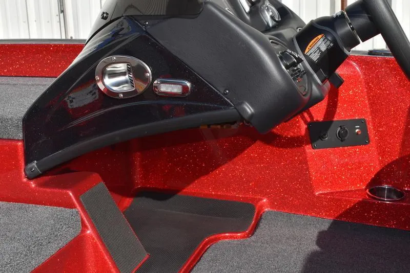 Slide: The Image of 2024 Triton 179 TrX boat dashboard with red metallic finish and control panel. - 23