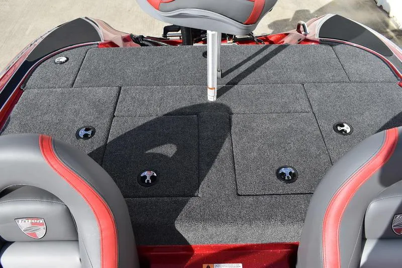 Slide: The Image of 2024 Triton 179 TrX boat deck with gray carpet and red-accented seats. - 24