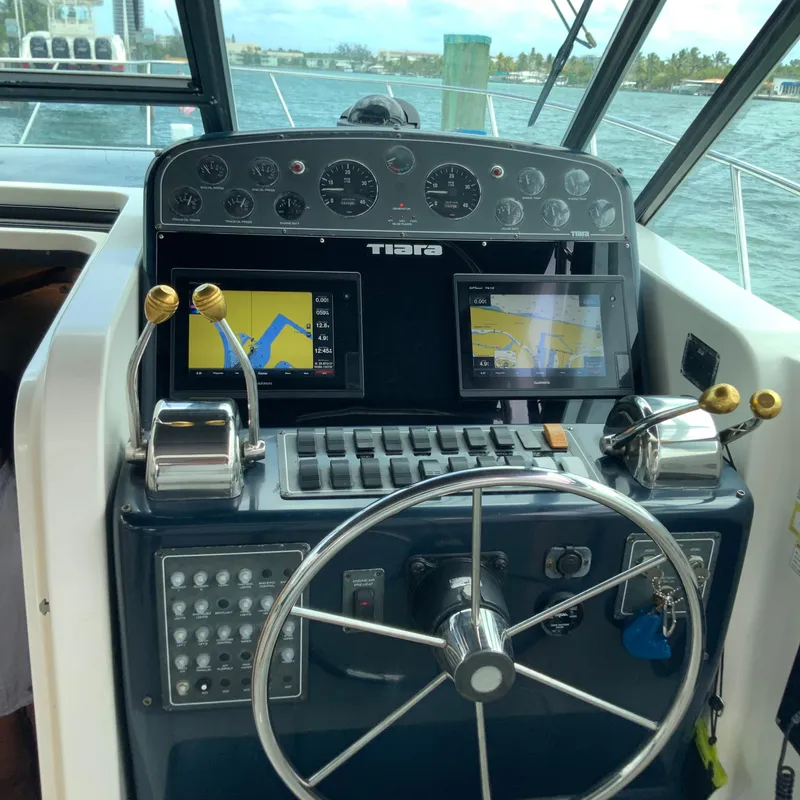 Slide: The Image of Tiara Sport 35 Open 2000 boat dashboard with navigation screens and steering wheel. - 9