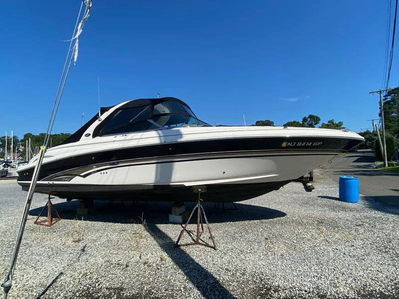 Slide: The Image of 2001 Sea Ray 290 Bowrider boat on dry dock under clear blue sky. - 0