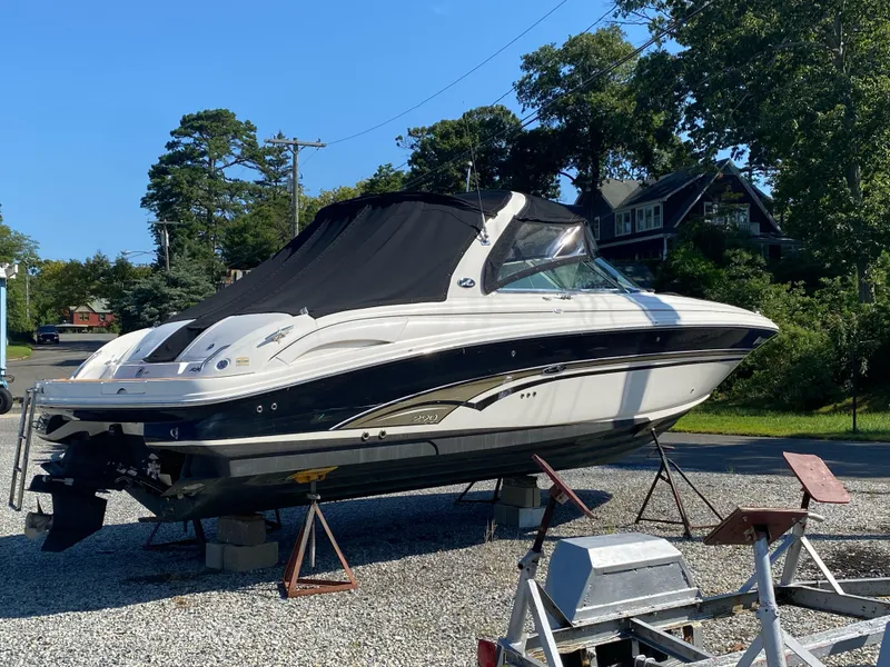 Slide: The Image of 2001 Sea Ray 290 Bowrider boat on stands, covered, in a yard. - 1