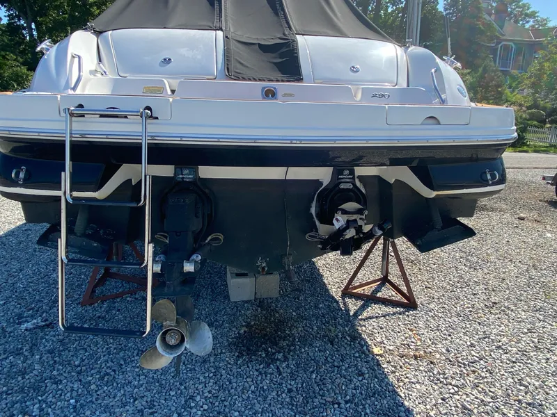 Slide: The Image of 2001 Sea Ray 290 Bowrider boat on stands, rear view with propellers and ladder. - 5