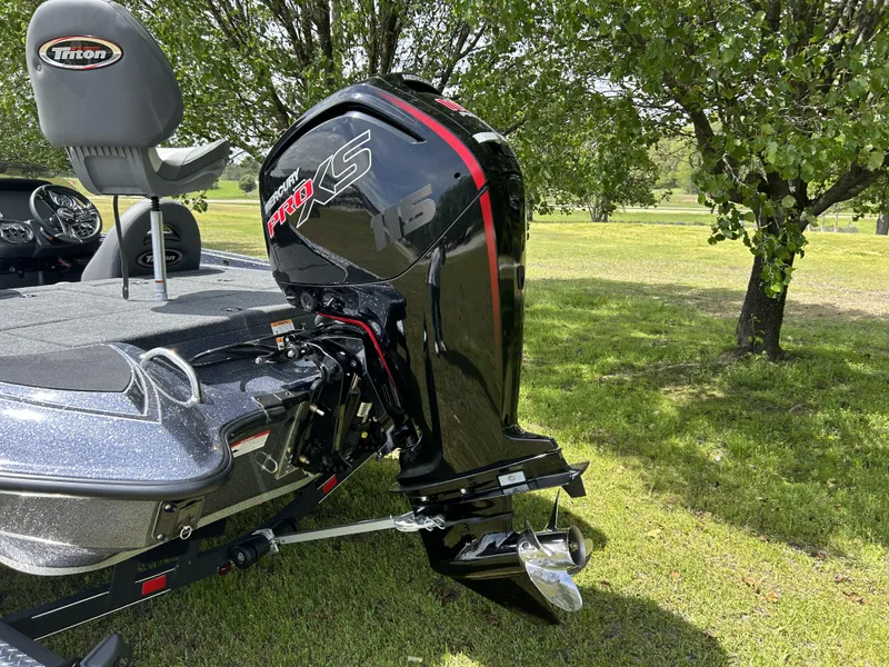 Slide: The Image of 2024 Triton 179 TrX boat with Mercury Pro XS engine in a grassy area. - 7