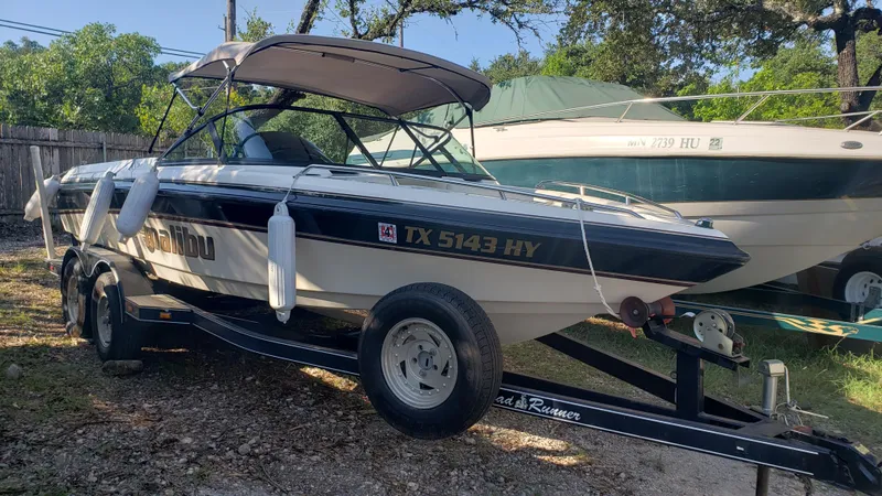 Slide: The Image of 1998 Malibu Sunsetter VLX boat on a trailer in a yard. - 1