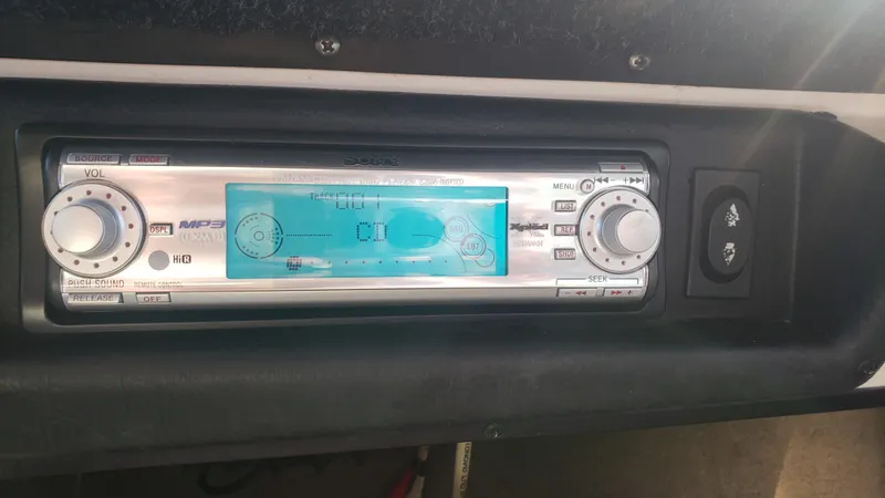 Slide: The Image of 1998 Malibu Sunsetter VLX boat stereo system with digital display and control knobs. - 11