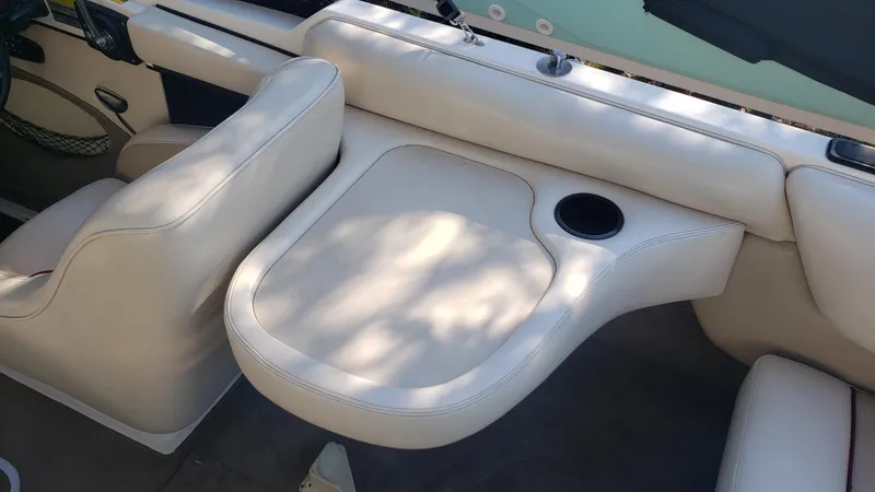 Slide: The Image of Interior seating of a 1998 Malibu Sunsetter VLX boat with beige upholstery. - 13
