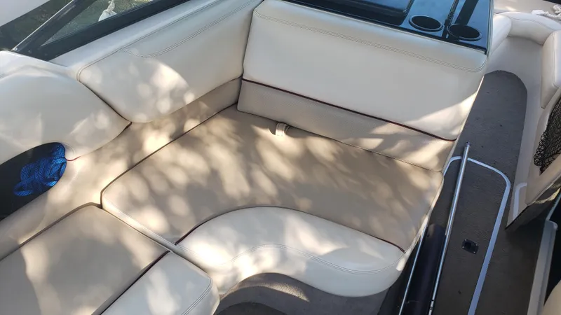 Slide: The Image of Interior seating of a 1998 Malibu Sunsetter VLX boat with beige upholstery. - 15