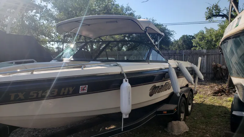 Slide: The Image of 1998 Malibu Sunsetter VLX boat on trailer with canopy in outdoor setting. - 2