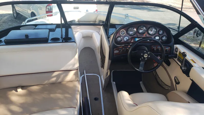 Slide: The Image of 1998 Malibu Sunsetter VLX boat interior with beige seating and detailed dashboard. - 8