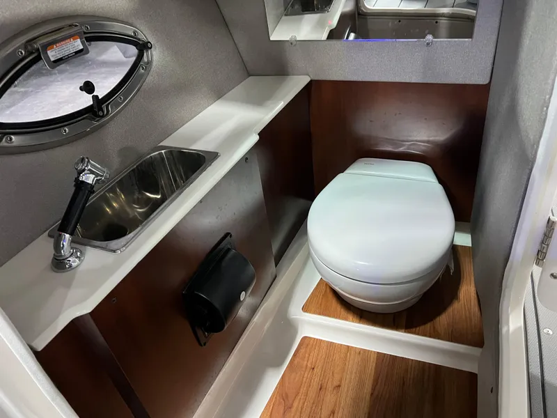 Slide: The Image of 2021 Chaparral 287 SSX boat bathroom with sink, toilet, and wood flooring. - 16