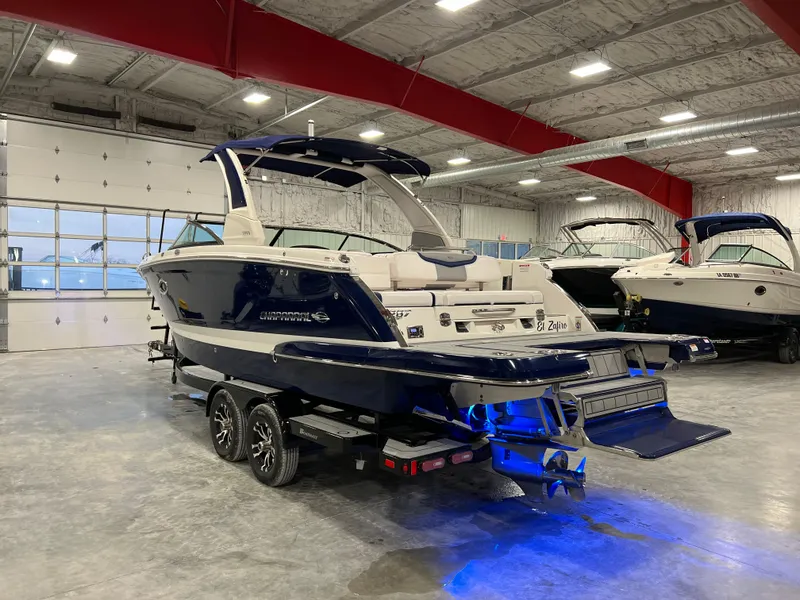 Slide: The Image of 2021 Chaparral 287 SSX boat on trailer in indoor showroom with blue lighting. - 3