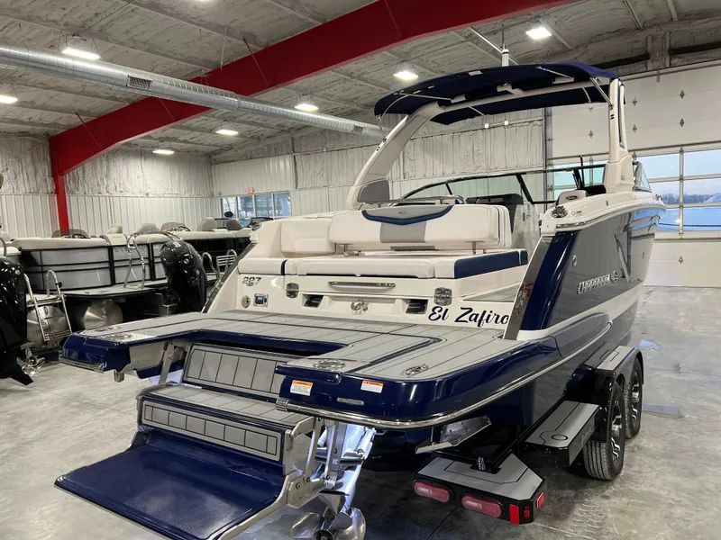 Slide: The Image of 2021 Chaparral 287 SSX boat in showroom, featuring sleek design and dual-axle trailer. - 8