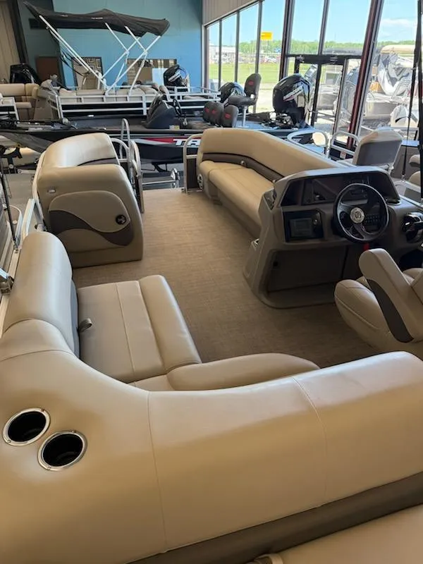 Slide: The Image of 2024 Sun Tracker Party Barge 18 DLX interior with beige seating and steering console. - 3