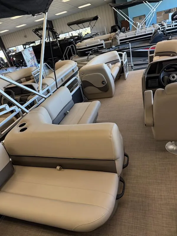 Slide: The Image of 2024 Sun Tracker Party Barge 18 DLX interior with beige seating in showroom. - 4