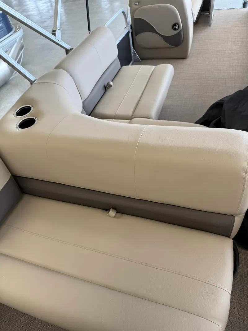 Slide: The Image of 2024 Sun Tracker Party Barge 18 DLX interior with beige seating and cup holders. - 5