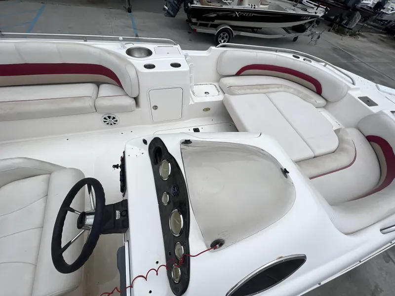 Slide: The Image of 2005 Hurricane 237 boat interior with white and red seating, steering wheel, and dashboard. - 10