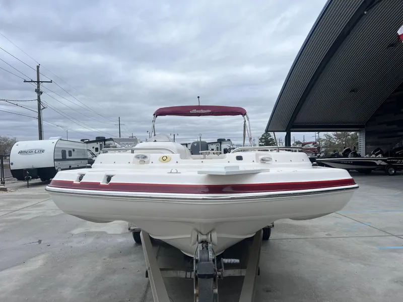 Slide: The Image of 2005 Hurricane 237 boat with red accents on a trailer at a dealership. - 5