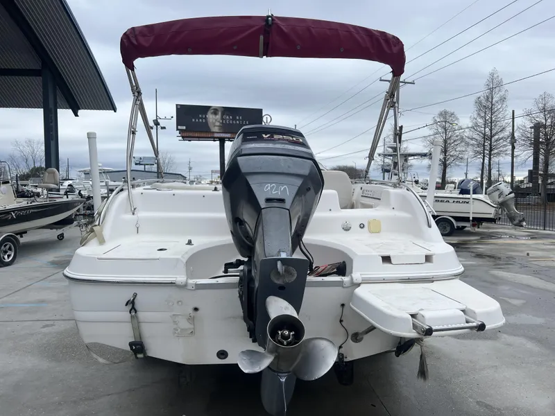 Slide: The Image of 2005 Hurricane 237 boat with outboard motor and red canopy in a marina. - 6