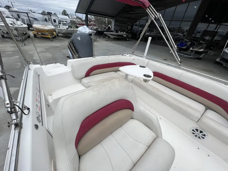 Slide: The Image of 2005 Hurricane 237 boat interior with white and red seating, docked at a marina. - 9