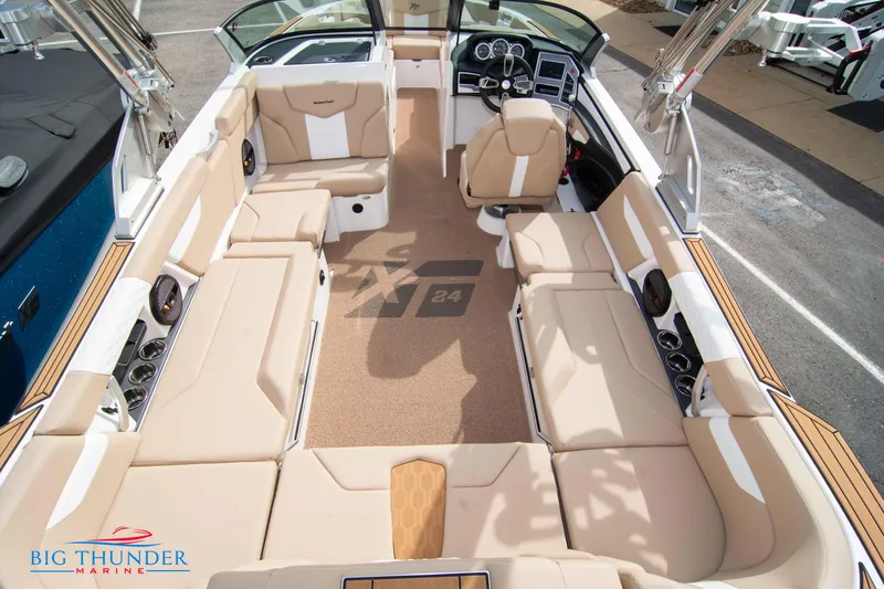 Slide: The Image of 2024 MasterCraft XT24 boat interior with beige seating and modern dashboard. - 14