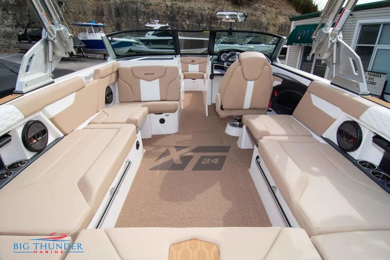 Slide: The Image of 2024 MasterCraft XT24 boat interior with beige seating and carpet. - 16