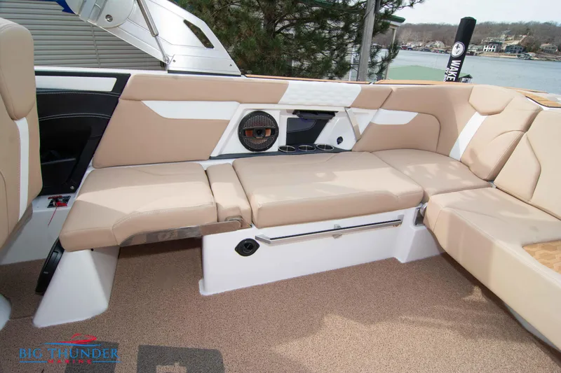 Slide: The Image of 2024 MasterCraft XT24 boat interior with beige seating and built-in speaker. - 17