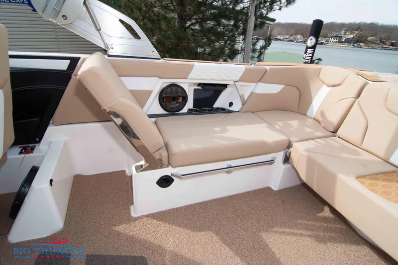 Slide: The Image of 2024 MasterCraft XT24 boat interior with beige seating and speaker system. - 18