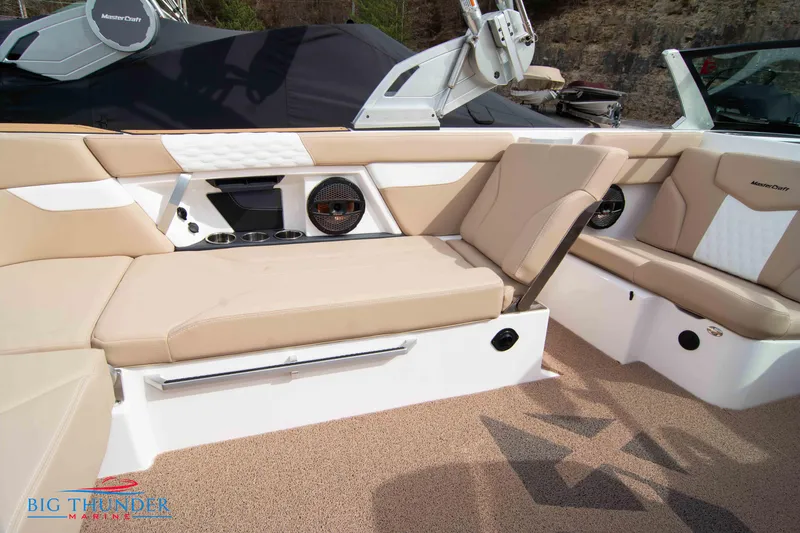 Slide: The Image of 2024 MasterCraft XT24 boat interior with beige seating and premium audio system. - 20