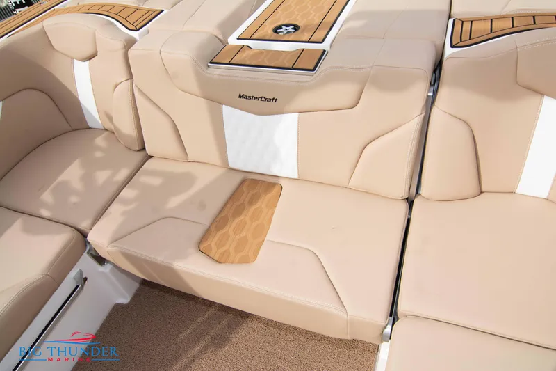 Slide: The Image of 2024 MasterCraft XT24 boat interior with beige and white cushioned seating. - 21