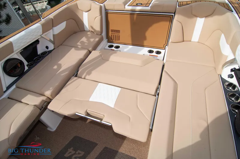Slide: The Image of 2024 MasterCraft XT24 boat interior with beige seating and cup holders. - 23