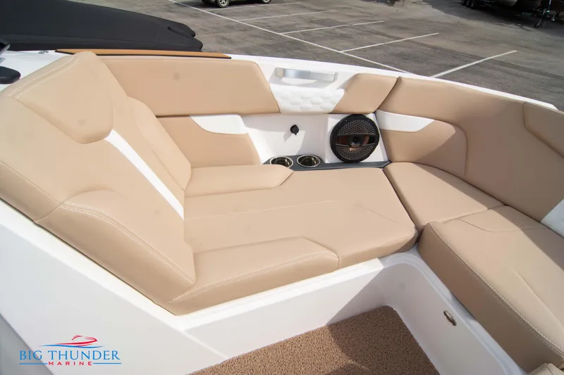 Slide: The Image of 2024 MasterCraft XT24 boat interior with beige seating and cup holders. - 43