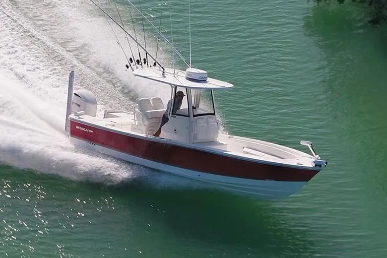 Slide: The Image of 2024 Regulator 26XO boat with Yamaha outboard motor, docked on a sunny day. - 2