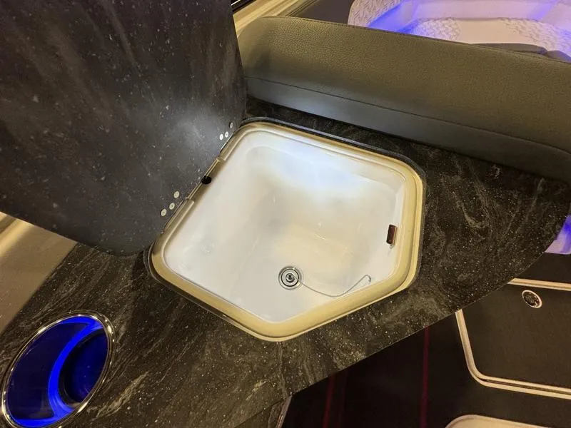 Slide: The Image of 2025 Fountain 43 SCX boat interior sink with modern design and blue LED lighting. - 11