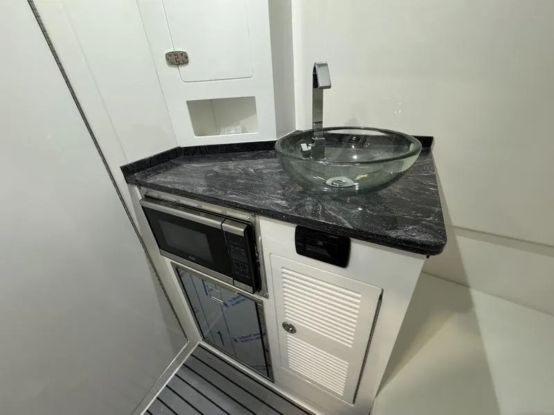 Slide: The Image of Modern kitchenette in 2025 Fountain 43 SCX boat with glass sink and microwave. - 25