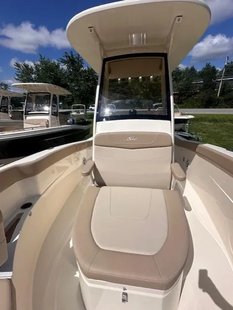 Slide: The Image of 2025 Scout 240 XSF boat interior with seating and console under a clear blue sky. - 10
