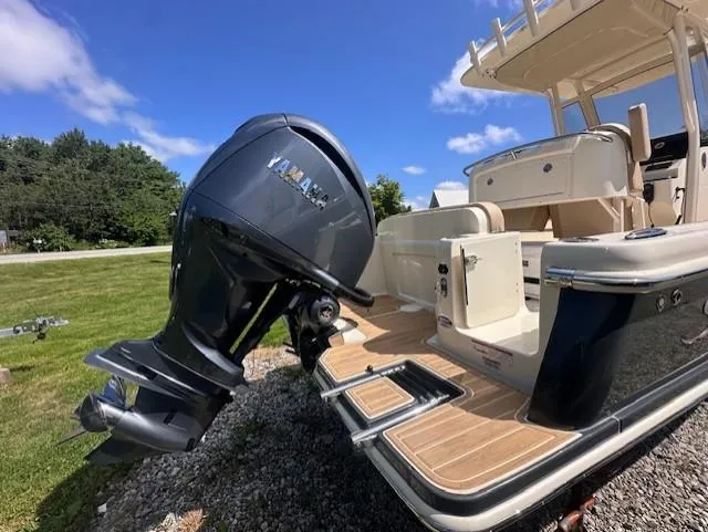 Slide: The Image of 2025 Scout 240 XSF boat with Yamaha outboard motor, docked on grassy area. - 3