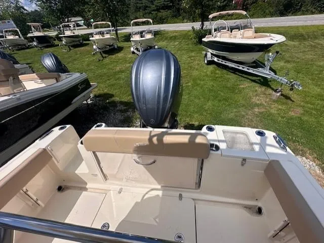 Slide: The Image of 2025 Scout 240 XSF boat with outboard motor, displayed on grass with other boats. - 6