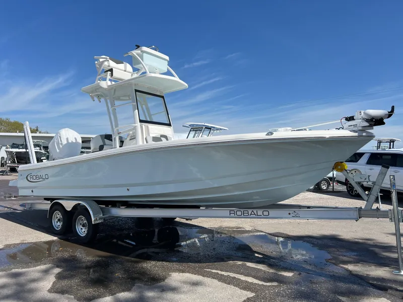 The Image of 2024 Robalo 246 Sky Deck boat on a trailer under a clear blue sky. - 0