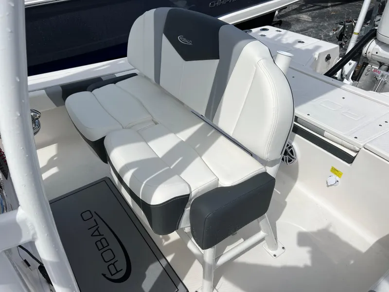 Slide: The Image of 2024 Robalo 246 Sky Deck boat seating area with white and gray upholstery. - 11