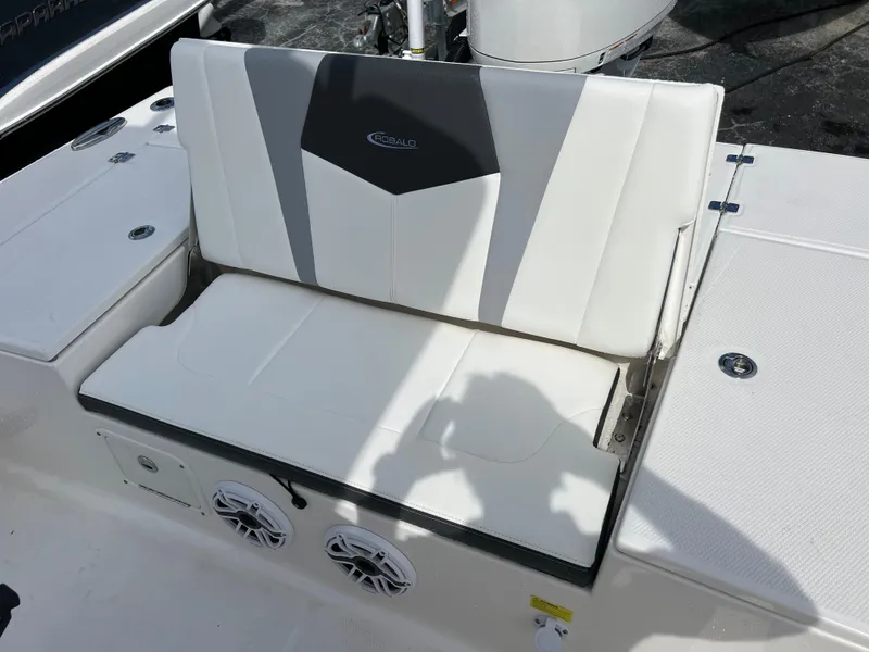 Slide: The Image of 2024 Robalo 246 Sky Deck boat with white cushioned seating and built-in speakers. - 15