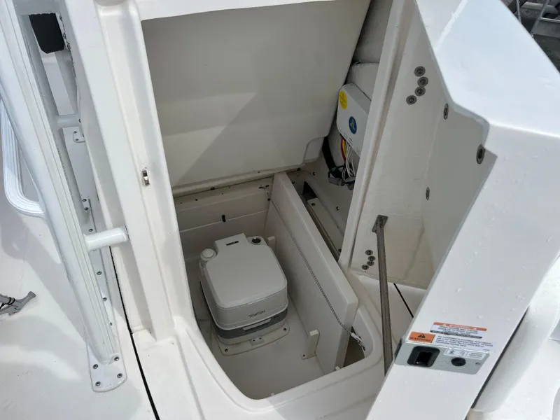 Slide: The Image of 2024 Robalo 246 Sky Deck boat interior storage compartment with portable toilet. - 16