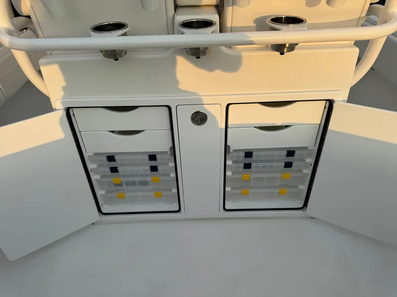 Slide: The Image of 2024 Regulator 28 boat storage compartments with open doors and organized tackle boxes. - 18
