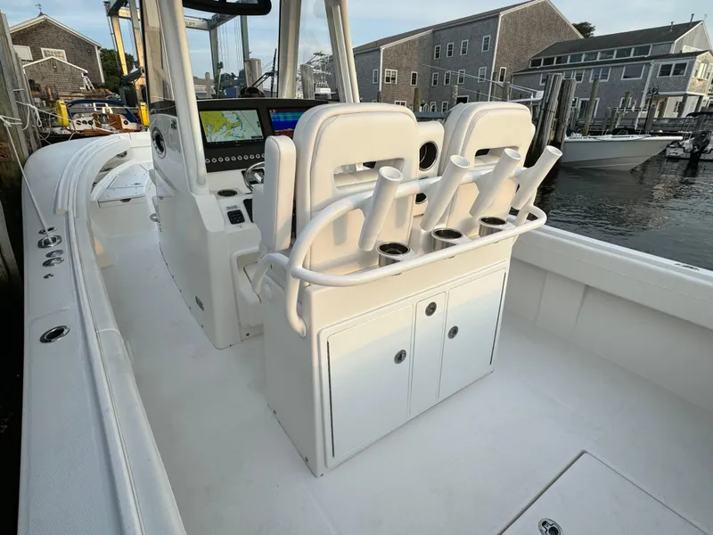 Slide: The Image of 2024 Regulator 28 boat interior with helm seats and rod holders at a dock. - 20
